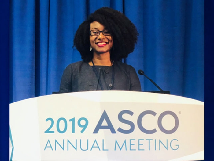 Christina Chapman MD at the speakers podium at the 2019 American Society of Clinical Oncology’s annual meeting