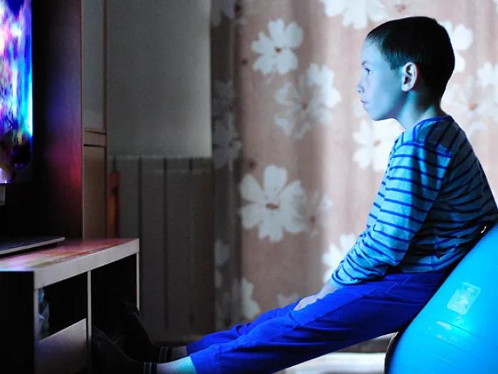 child sitting exercise ball tv