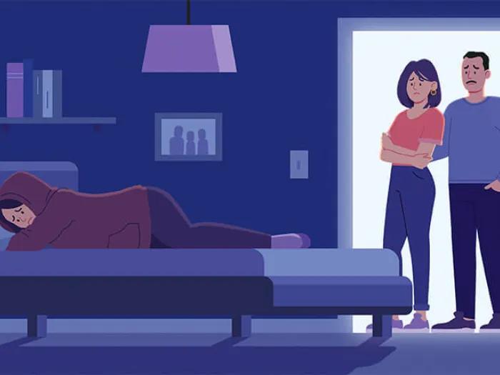 Parents standing at doorway near depressed teenagers bed