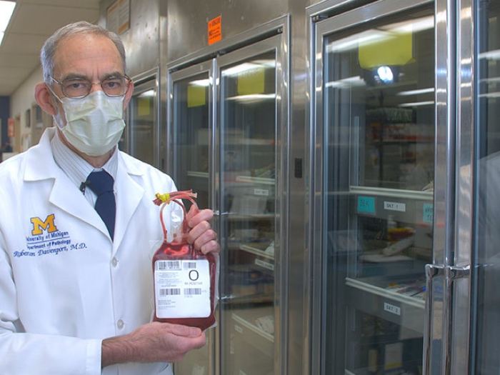 doctor in mask holding blood bag