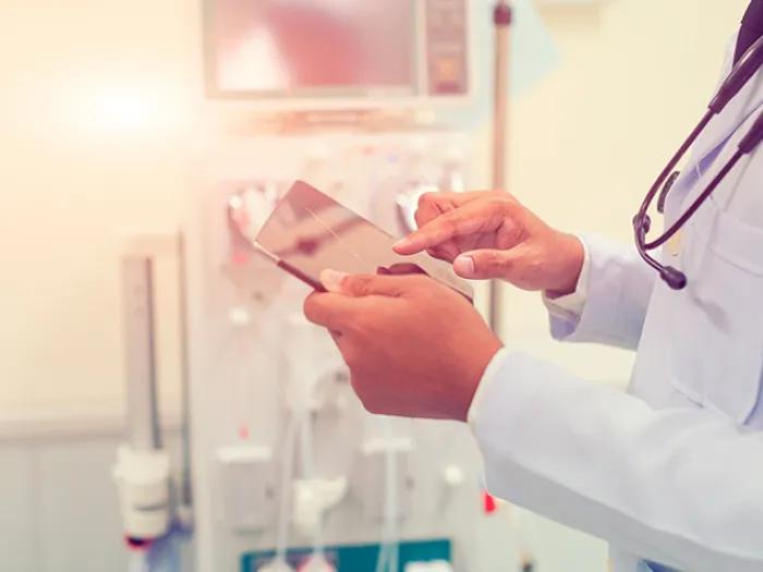 doctor holding tablet hospital room with stethoscope