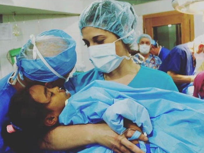 Doctor holding child in surgical gear