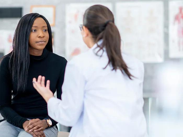 Doctor talking with patient in exam room.