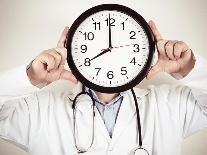 physician holding clock for head
