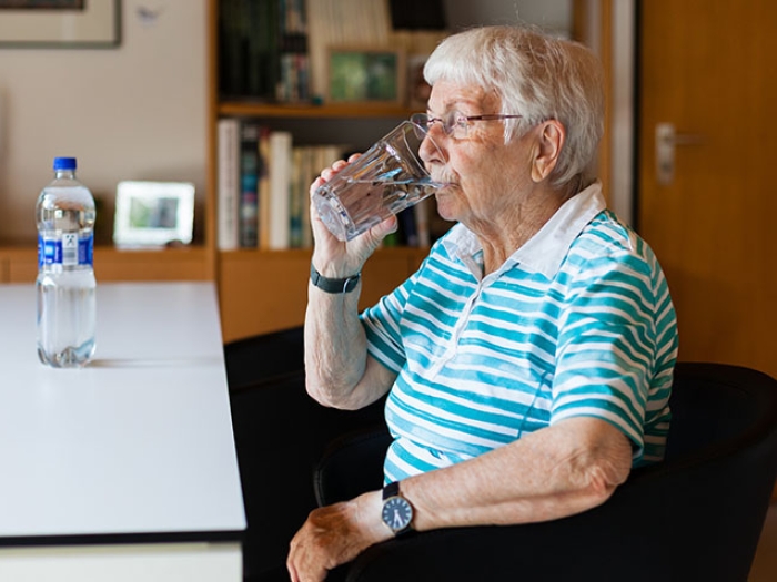 Patient at desk drinking a fluid
