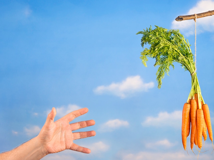 hand reaching for carrot sticks in air with blue sky background