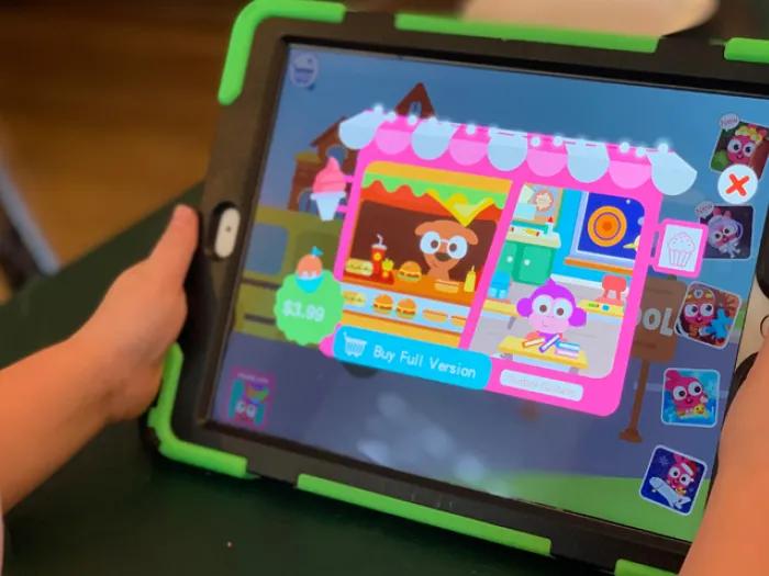 kid holding ipad with games on it