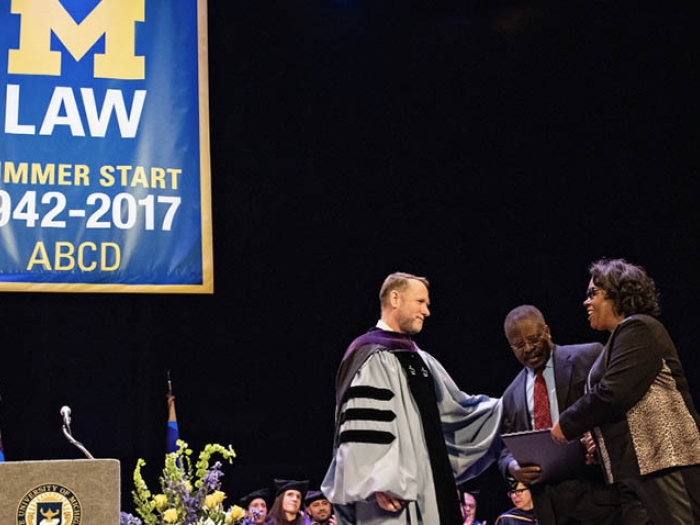 Parents being handed law degree at U-M law school ceremony