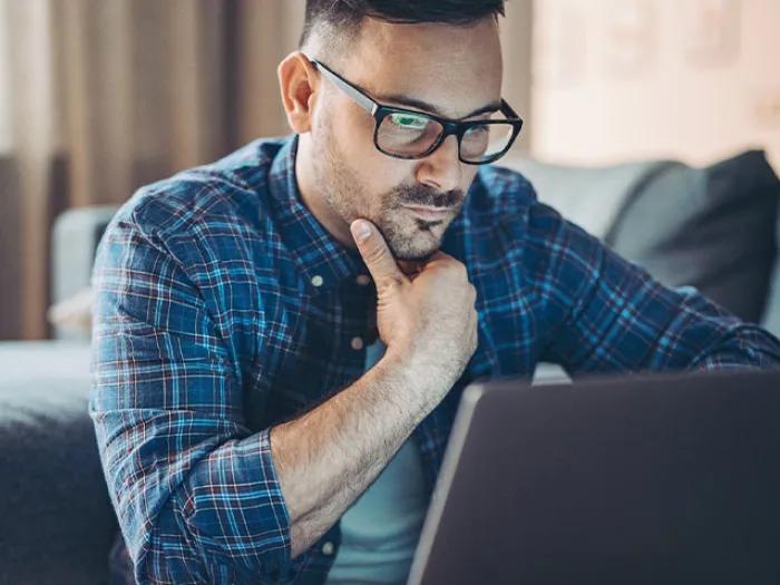 man worried looking at laptop