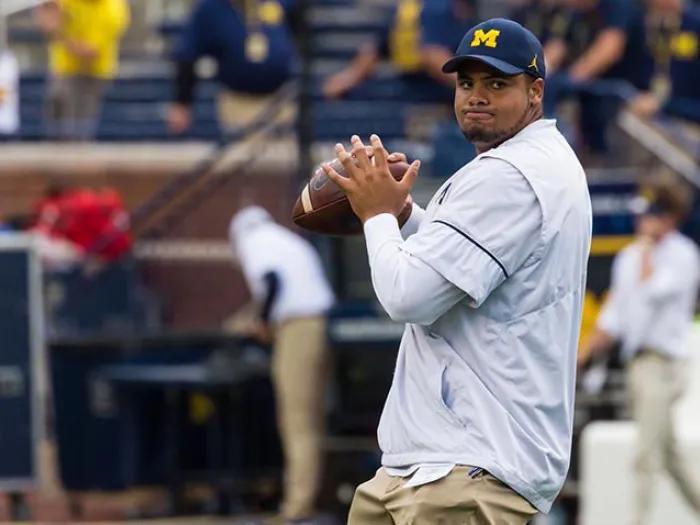 Michigan football player throwing football