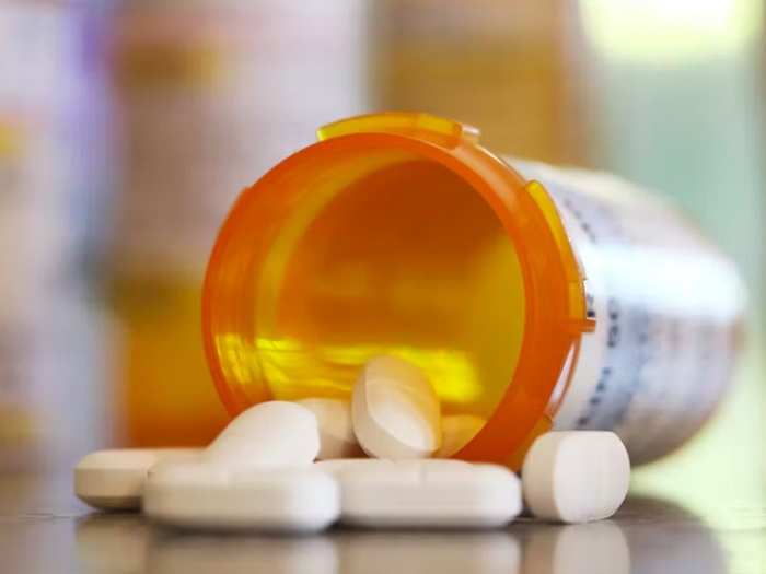 pills meds falling out on table orange bottle white pills