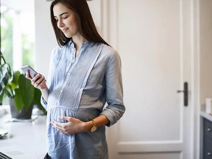 Pregnant lady using technology to check in with doctor