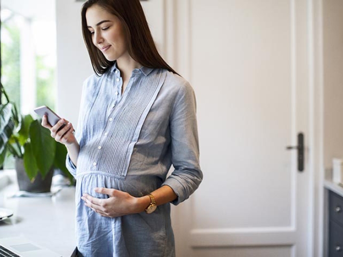 Pregnant lady using technology to check in with doctor