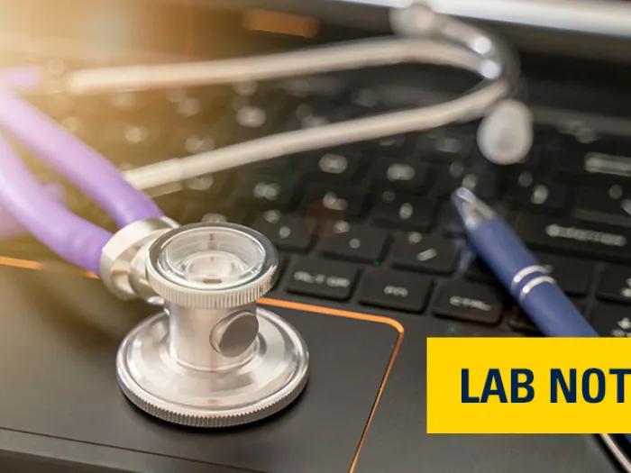 stethoscope black laptop keyboard pen with light in left corner