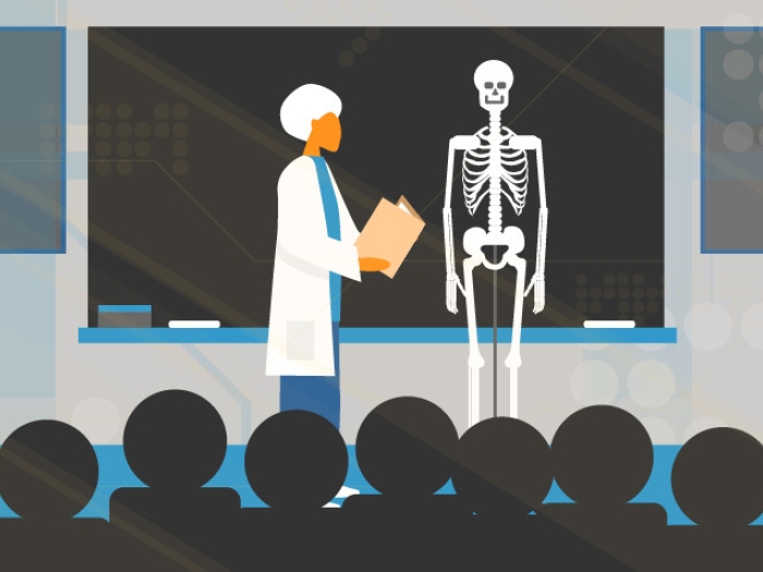 Teacher with white hair in classroom teaching students with skeleton in front of blackboard