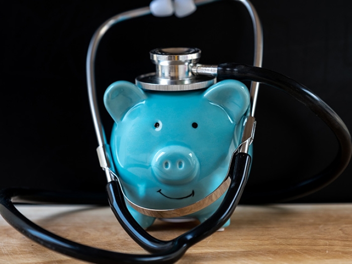 Teal Piggy Bank with Stethoscope on Desk