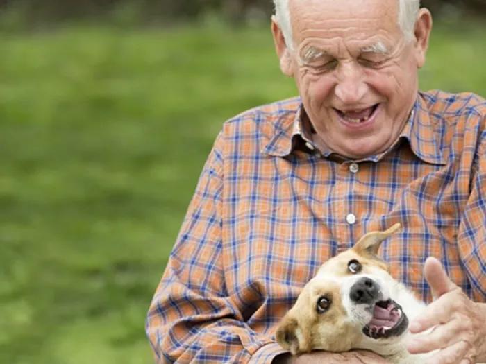 Older man rubbing a dog's neck