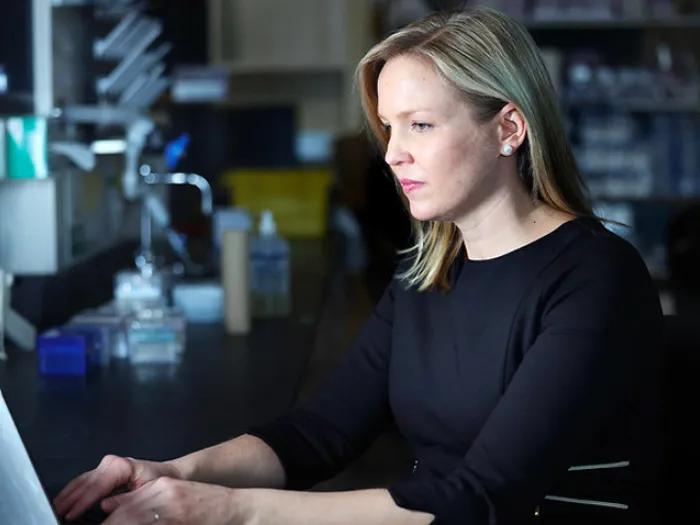 woman scientist laptop lab dark