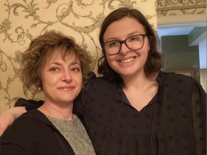 mother and daughter standing smiling at camera together
