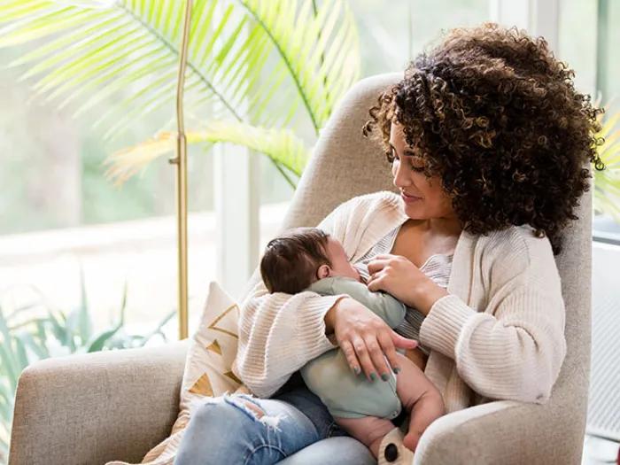 Women holding newborn in rocking chair