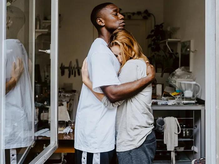 young man hugging woman in window