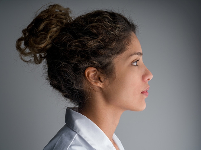 young woman doctor anxious worried side view with hair up white coat
