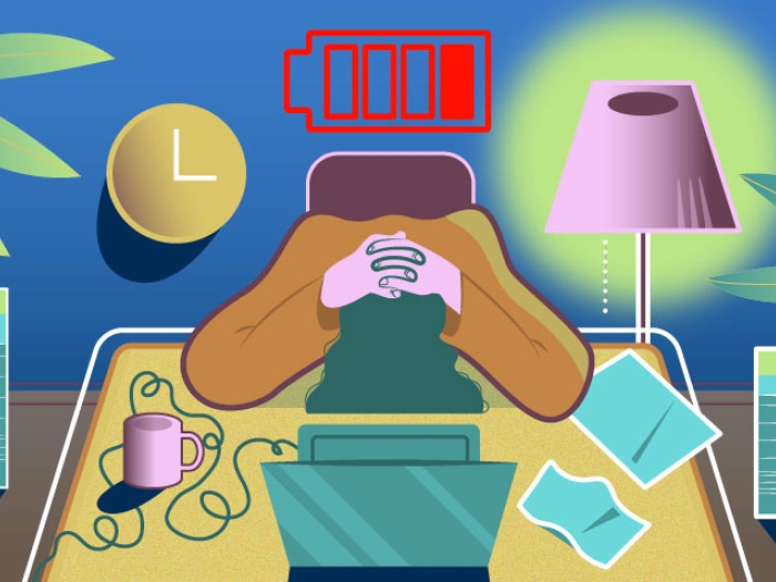 Person with head on desk with hands on head sleeping by computer and coffee cup