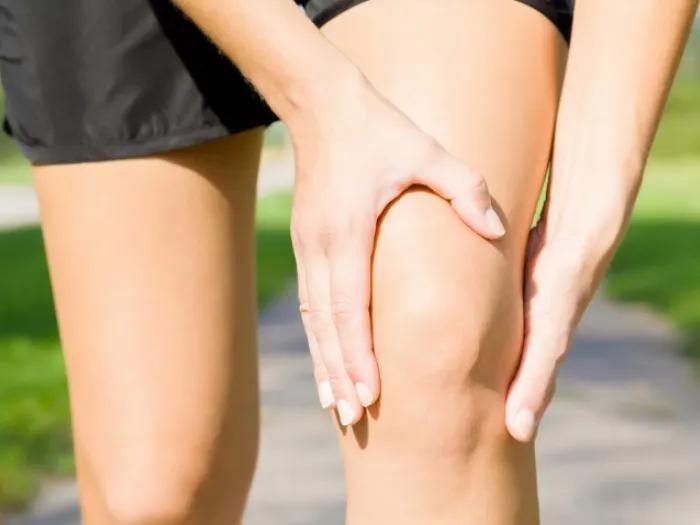Woman in shorts holding her knee