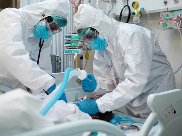 Doctors inserting ventilator tube hazmat suits