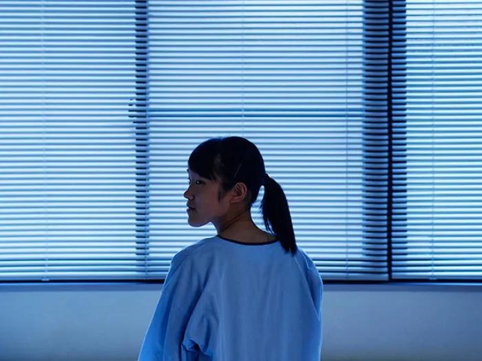girl in room looking back grey