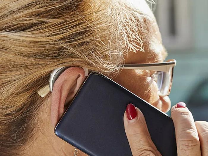 Women on cell phone with hearing aid