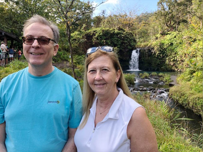 husband and wife near a waterfall