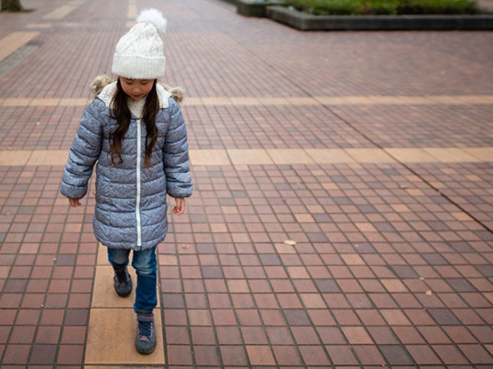 Little girl walking on brick path