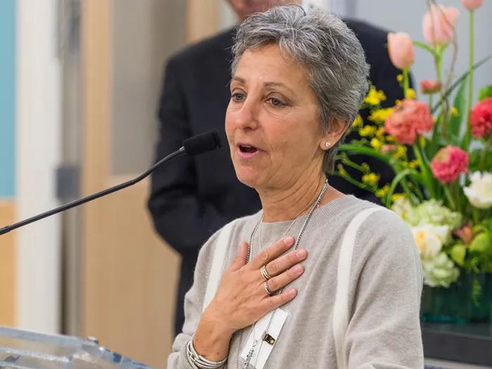 woman at mic. with hand over her heart