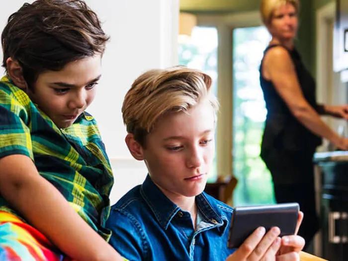 Parent looking concerned at children watching phone screen a lot