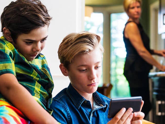 Parent looking concerned at children watching phone screen a lot