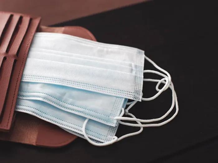 brown wallet with face masks