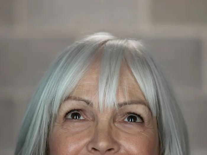 Woman with white hair looking up