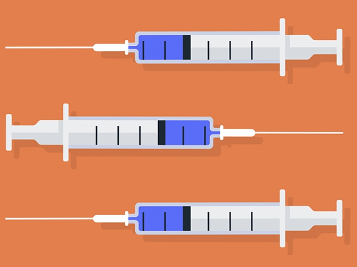 Three syringes with vaccine on orange background
