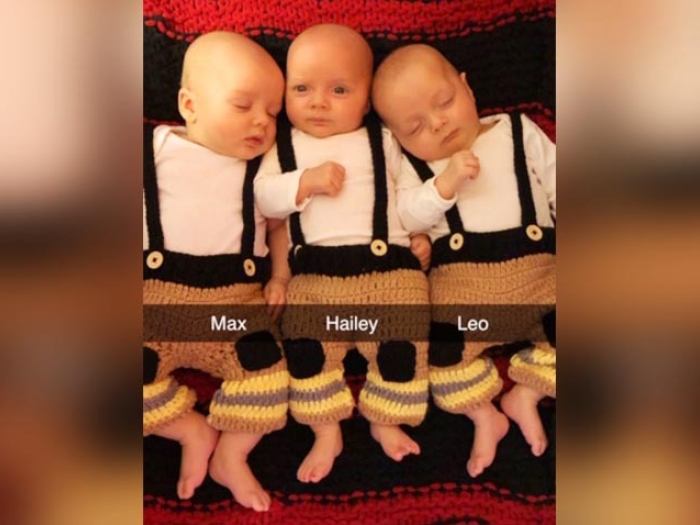 newborn triplets dressed in firefighter outfits