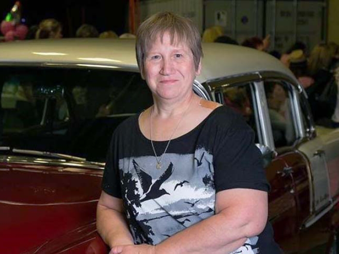 Woman standing in front of classic car