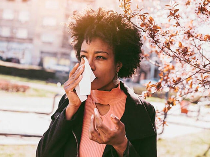 Women with kleenex wiping tear from fall allergies