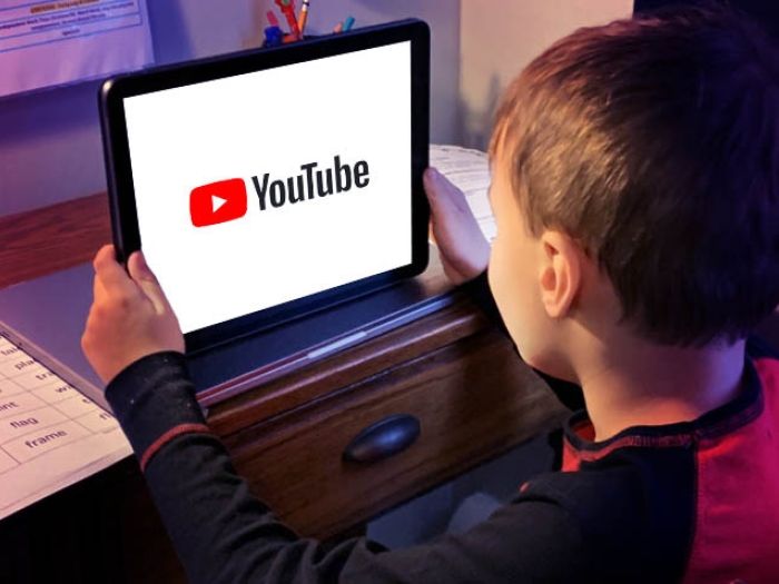 kid sitting watching youtube on tablet screen