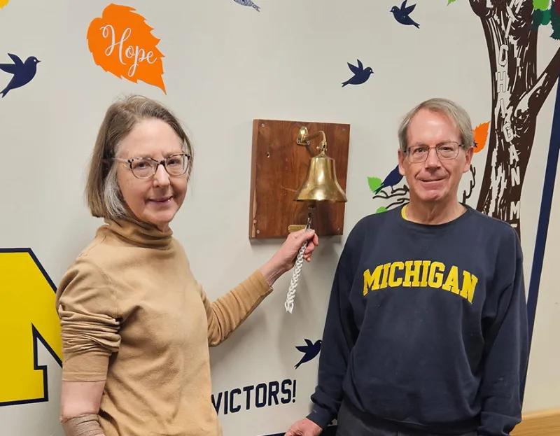 The Achtenbergs smile as Connie rings the bell to mark her last radiation treatment.