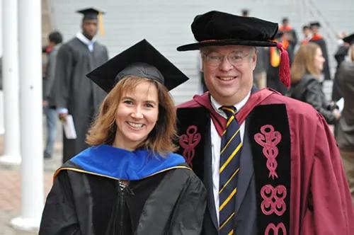 Smiling portrait of Moyer and Johnson standing together at Moyer's Ph.D. ceremony.