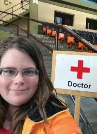 Selfie of a woman standing next to a sign that says doctor.