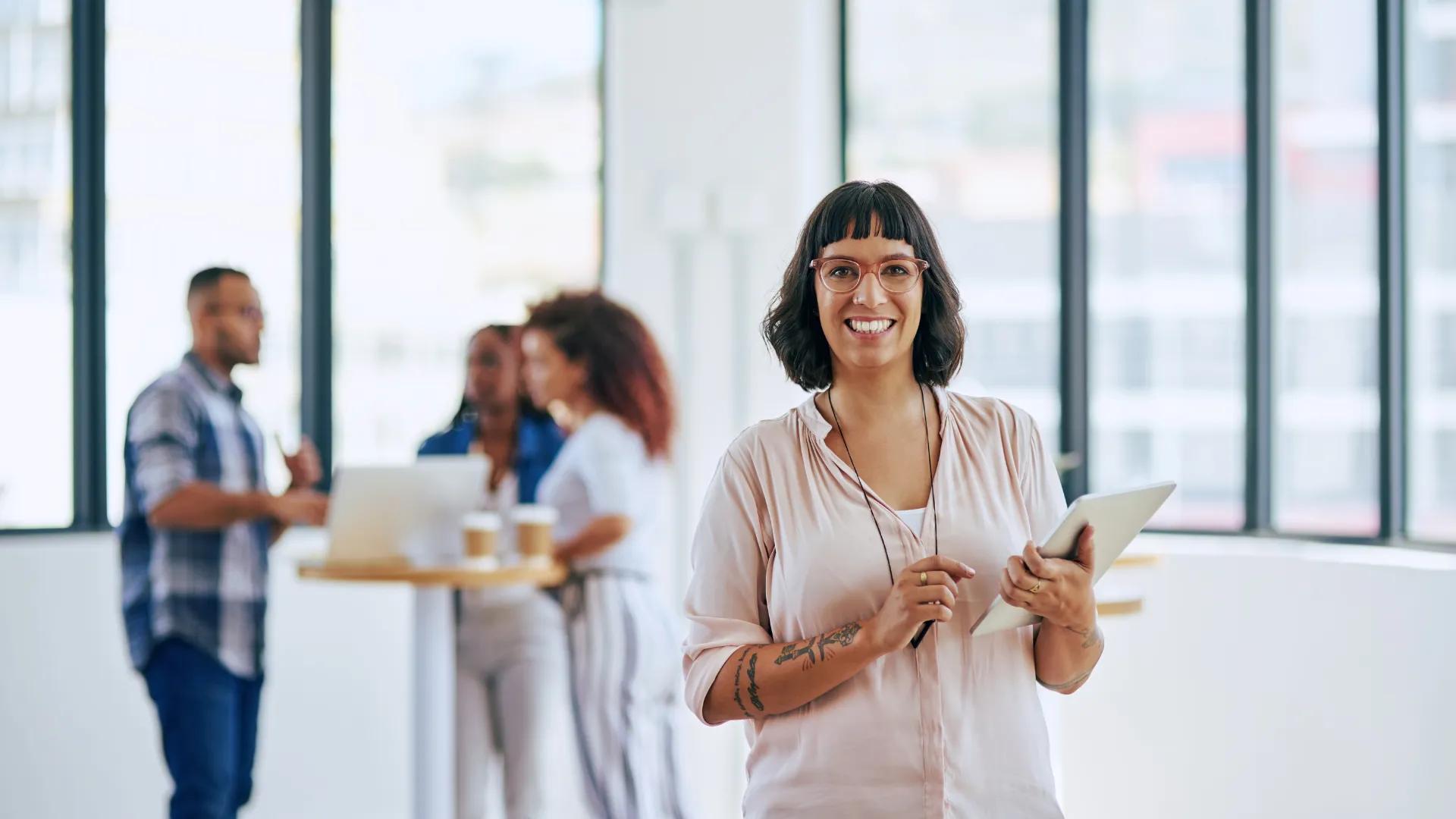 Woman holding file in the hand smiles for the camera.