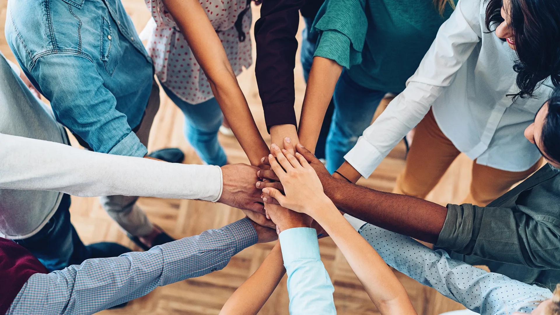Multi-ethnic people holding hands in a circle. 