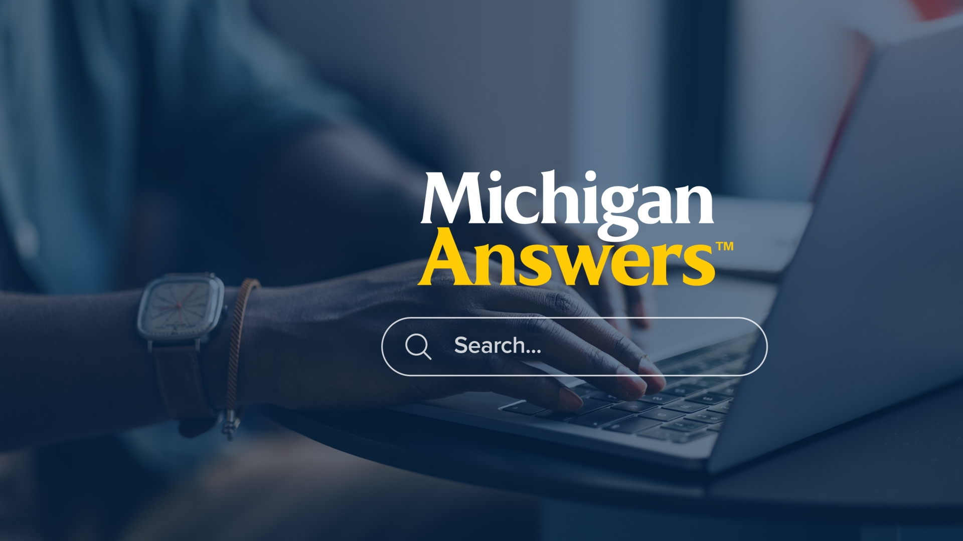Michigan Answers with a search box underneath and hands on a laptop keyboard with gray overlay in the background.