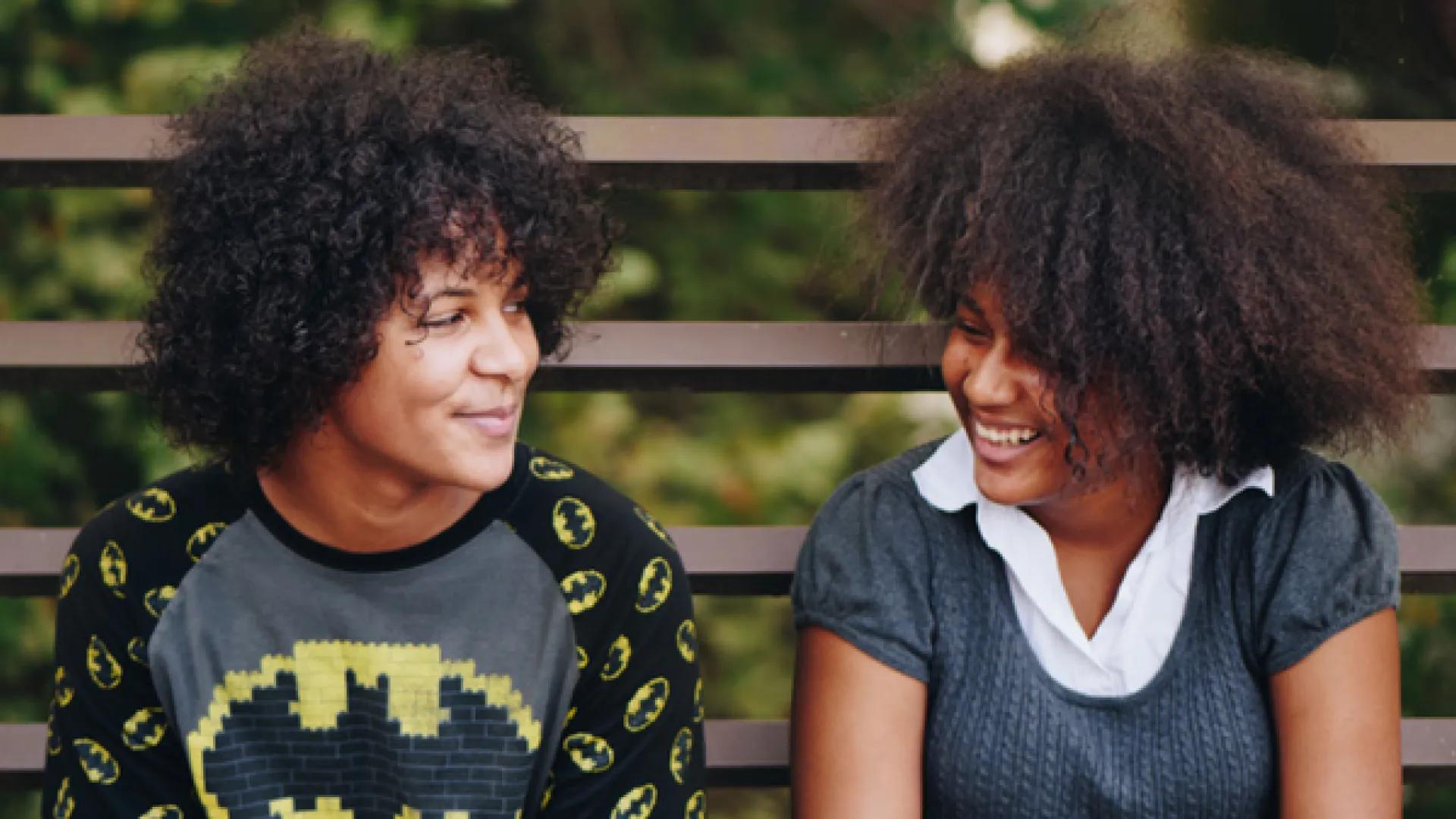 Two young women smile at each other
